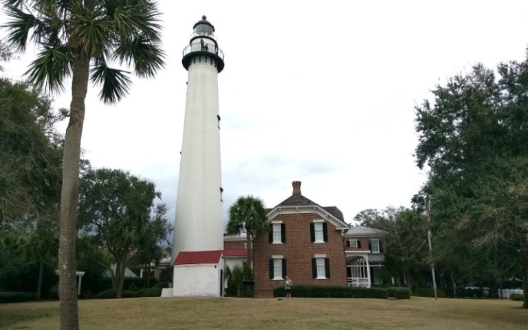 lighthouse next to building in park