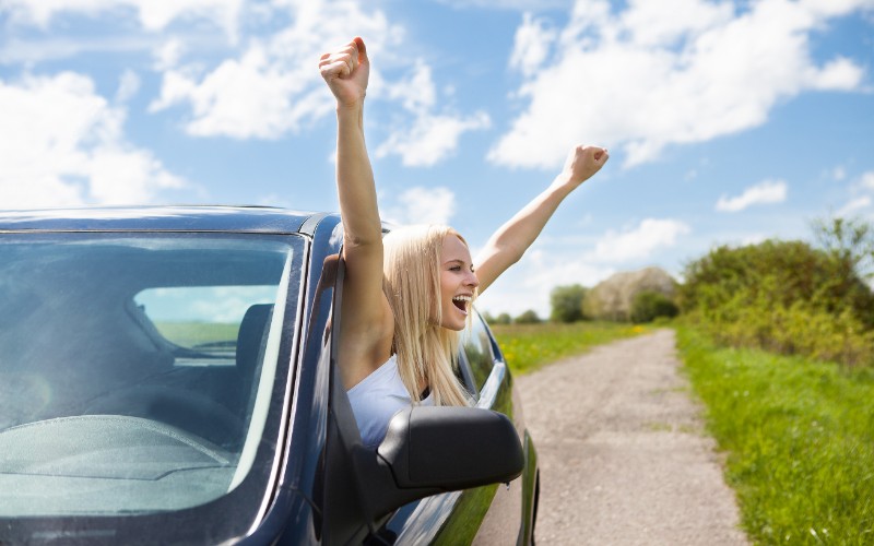 Woman Raising Hand Out Of Car Window