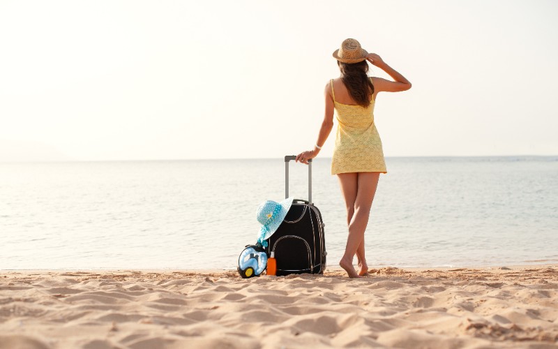 Woman with Suitcase at the Beach