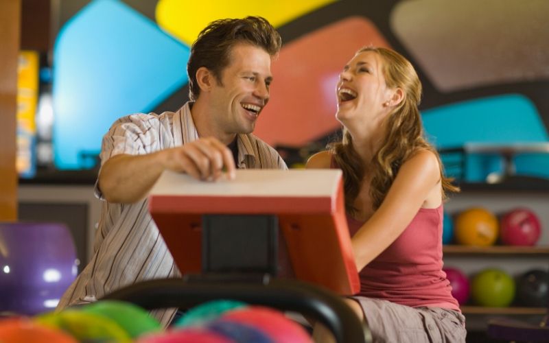 couple laughing at bowling machine