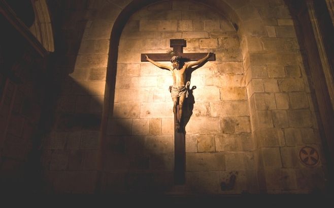 Jesus Christ wooden statue on a cross inside of a church