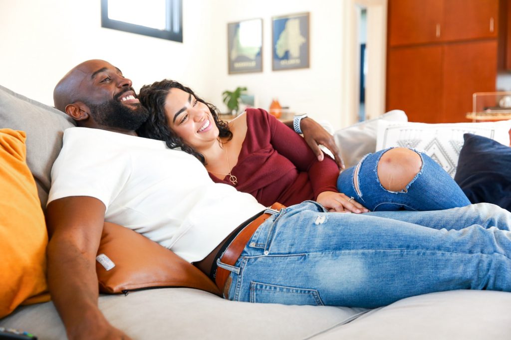 man and woman cuddling on couch