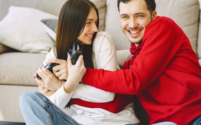 man and woman hugging while playing video games 