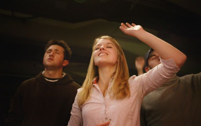 man and woman worshipping in church