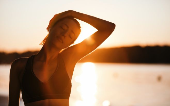 woman stretching outside during sunrise
