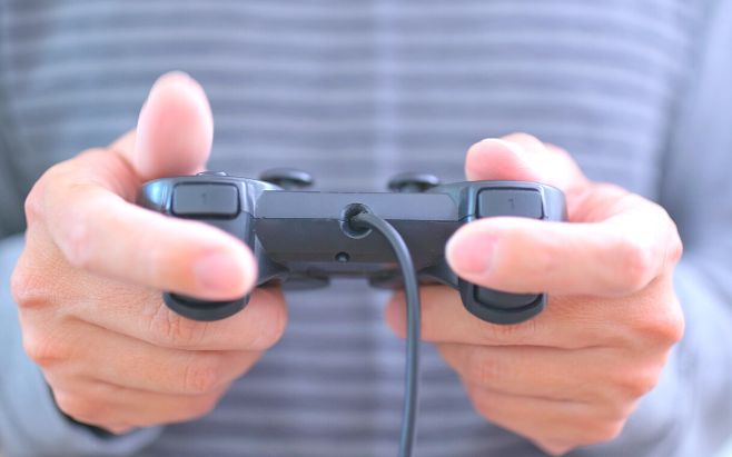 man hands holding video game controller