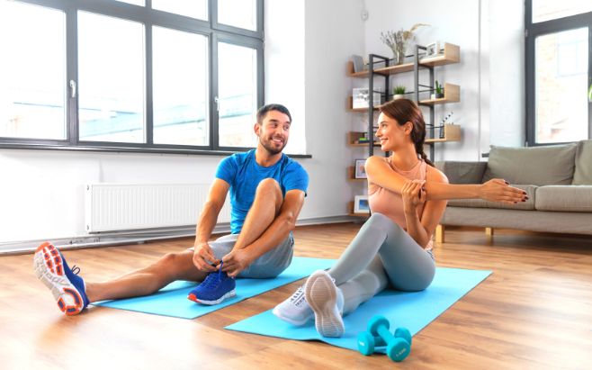 couple sitting on mats getting ready to exercise at home