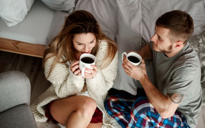 couple sitting on floor drinking coffee talking with each other