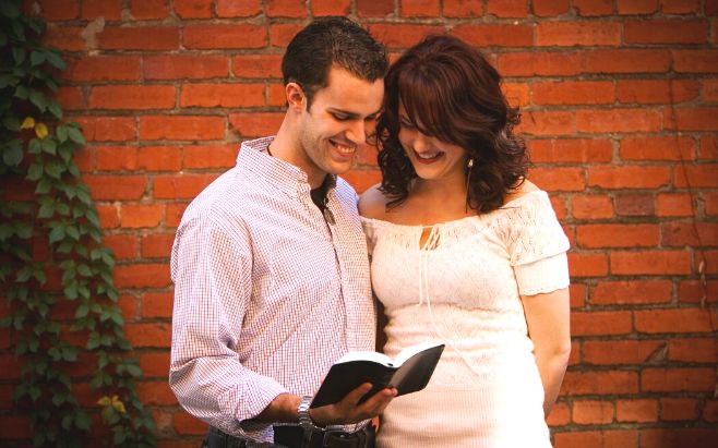 couple standing outside reading the Bible