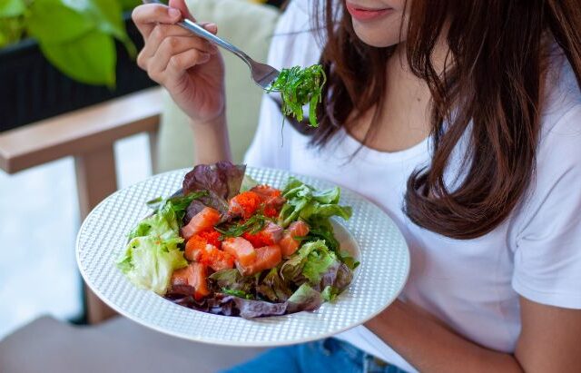woman eating a plate of salad